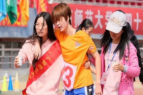义务工作人员搀扶着运动员.jpg